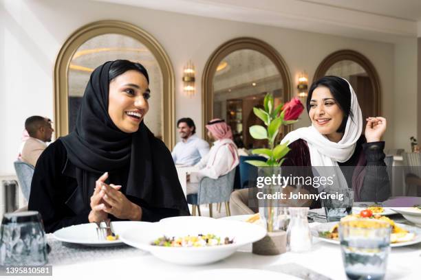 fröhliche saudische frauen, die im restaurant in riad zu mittag essen - saudi arabia people stock-fotos und bilder