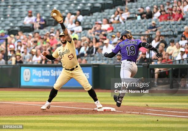 Christian Walker of the Arizona Diamondbacks catches a throw from pitcher Merrill Kelly as Charlie Blackmon of the Colorado Rockies is forced out at...