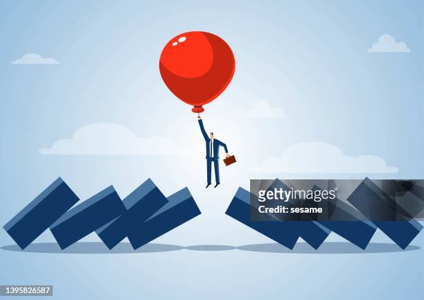 smart businessman predicts, manages and avoids financial risks, the balloon takes the businessman to fly into the air to avoid dominoes falling to hit the businessman, stop the impact and harm of the economic crisis. - escaping stock illustrations