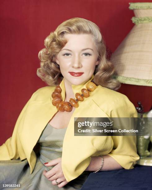 Gloria Grahame , US actress, wearing a yellow jacket over a green dress, with a large bead amber necklace around her neck, a studio portrait, circa...