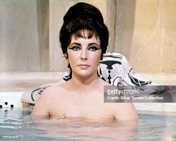Elizabeth Taylor , British actress, bathing with the water at chest height in a publicity still issued for the film, 'Cleopatra', 1963. The...