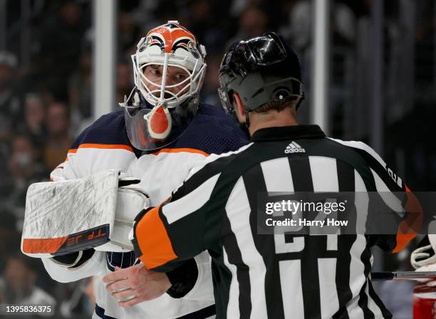 Mike Smith of the Edmonton Oilers gets help with his equipment from referee Graham Skilliter during the second period against the Los Angeles Kings...