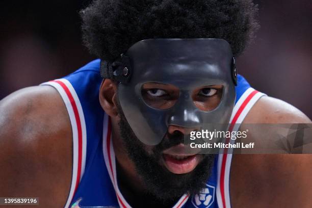 Joel Embiid of the Philadelphia 76ers looks on with his protective face guard against the Miami Heat during Game Three of the 2022 NBA Playoffs...