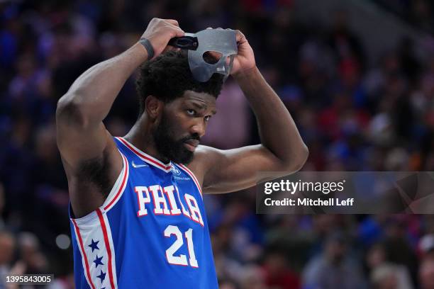 Joel Embiid of the Philadelphia 76ers puts on his protective face guard against the Miami Heat during Game Three of the 2022 NBA Playoffs Eastern...