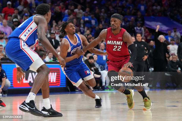 Jimmy Butler of the Miami Heat dribbles the ball against Paul Reed and Tyrese Maxey of the Philadelphia 76ers during Game Three of the 2022 NBA...