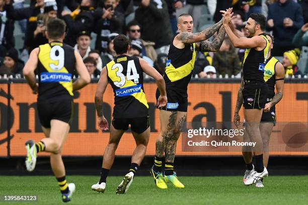 Dustin Martin of the Tigers is congratulated by team mates after kicking a goal during the round eight AFL match between the Richmond Tigers and the...