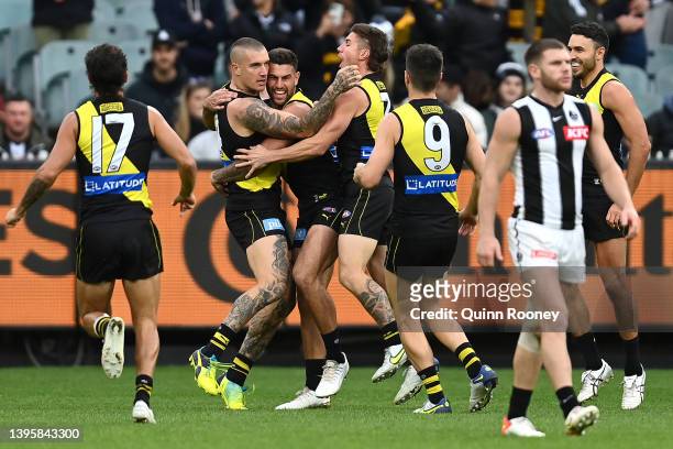 Dustin Martin of the Tigers is congratulated by team mates after kicking a goal during the round eight AFL match between the Richmond Tigers and the...