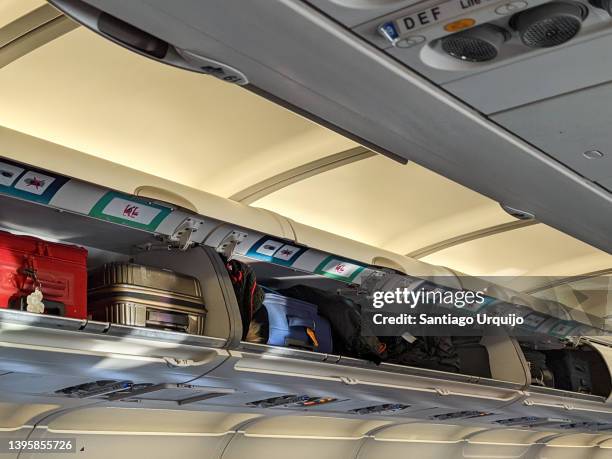 luggage within lockers on an airplane - passenger cabin stock pictures, royalty-free photos & images