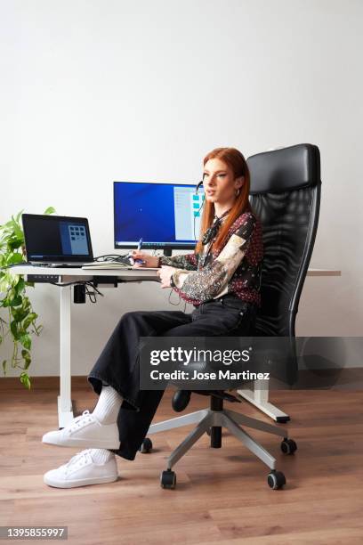 transgender man working in an office while talking on a headset - adjustable stock pictures, royalty-free photos & images