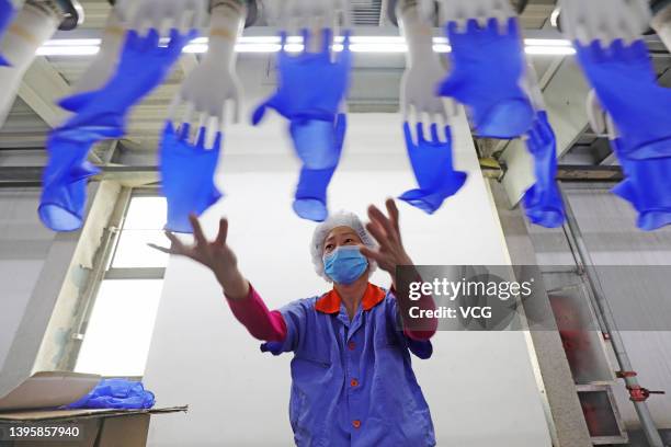 An employee works on a nitrile glove production line at a factory of Zhonghong Pulin Medical Products Co., Ltd on May 6, 2022 in Luannan County,...