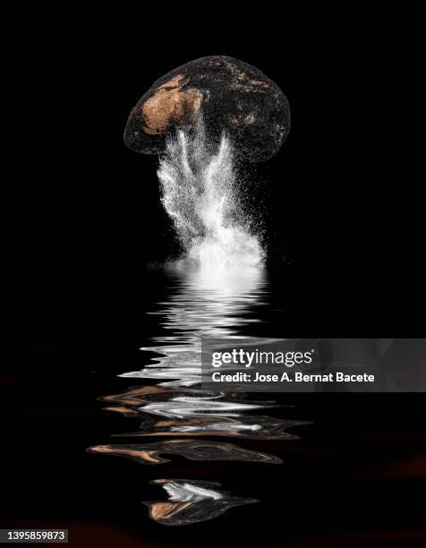 impact and explosion of a meteorite on a surface of water on a black background. - planet collision stock-fotos und bilder