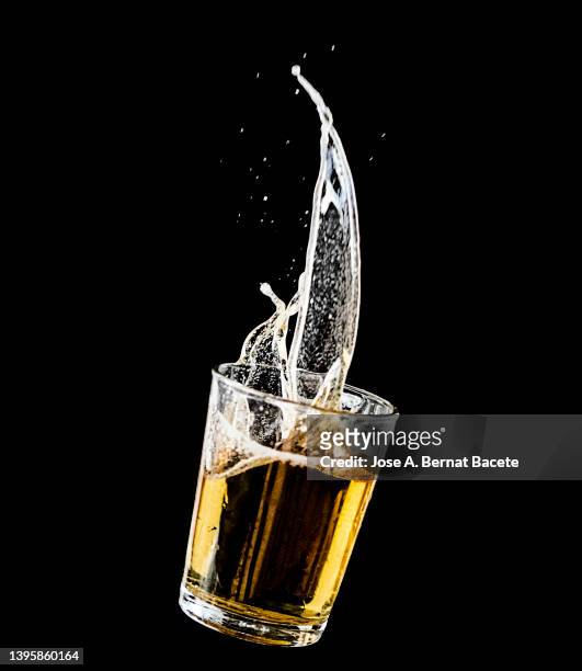 impact of a glass with beer falling to the ground on a black background. - beer splash stock pictures, royalty-free photos & images