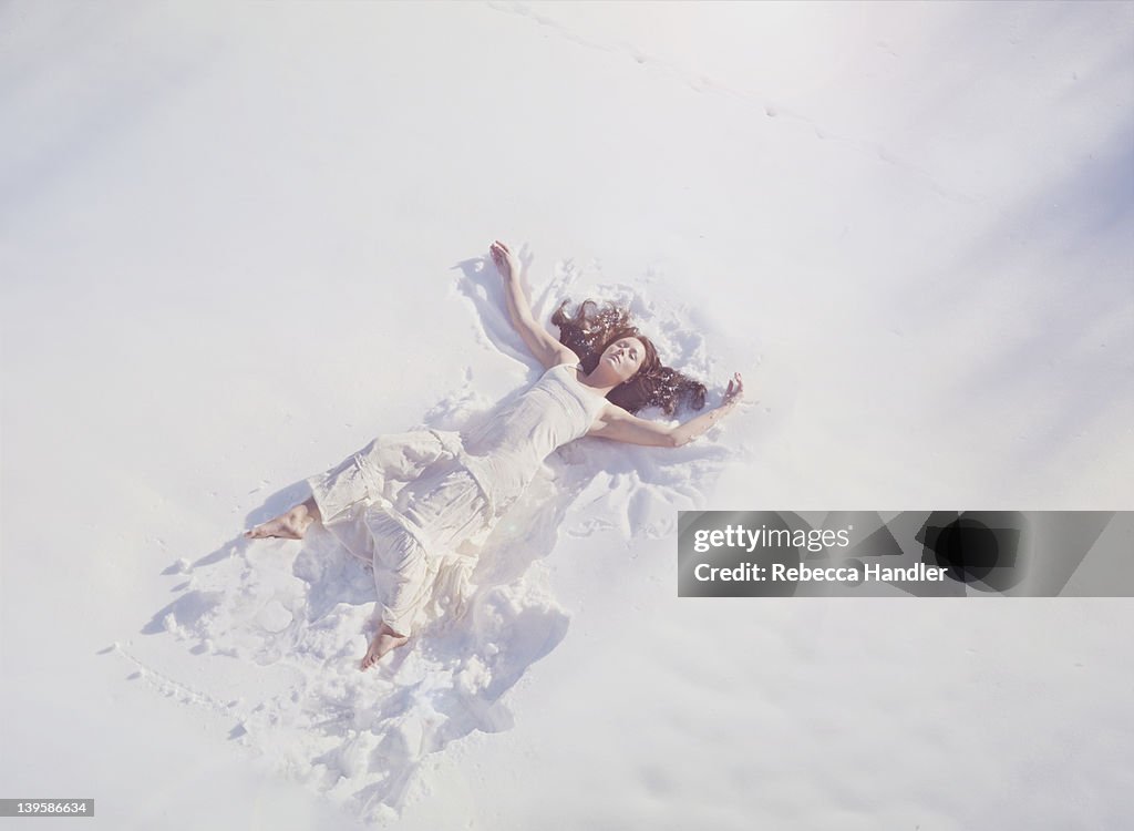 Clothed woman laying in the snow