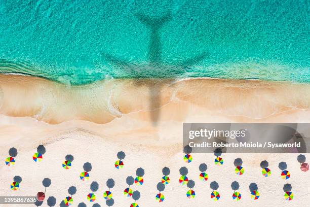 silhouette of airplane flying over idyllic tropical beach - airplane shadow stock pictures, royalty-free photos & images