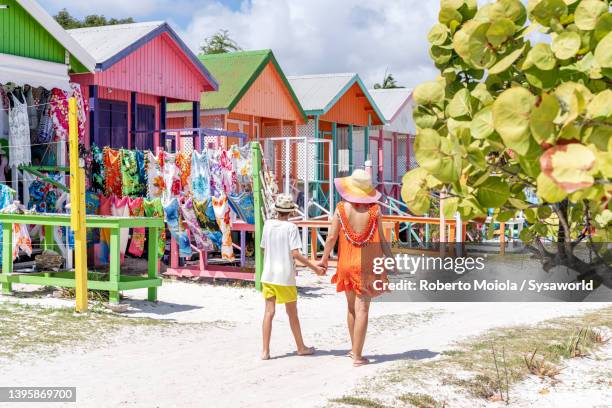 cute little boy with mother looking at souvenirs on a beach - caribbean culture stock-fotos und bilder