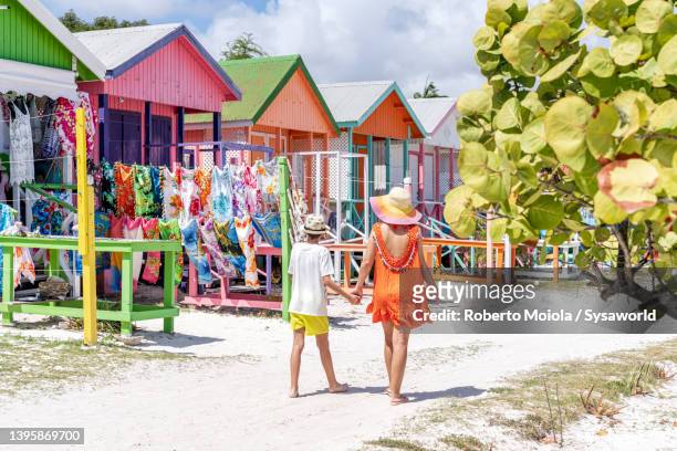 cute little boy with mother looking at souvenirs on a beach - antigua and barbuda stock pictures, royalty-free photos & images