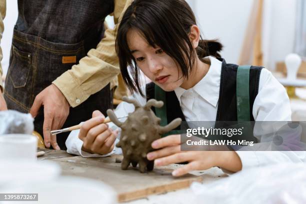 an asian woman learning to sculpt - sculptor stock-fotos und bilder