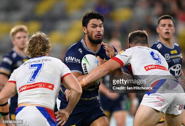 Jordan McLean of the Cowboys is tackled by Chris Randall of the Knights during the round nine NRL match between the North Queensland Cowboys and the...
