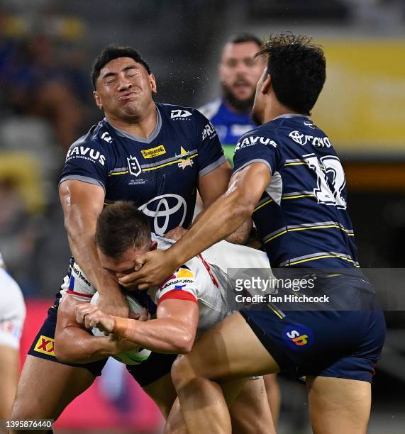 Chris Randall of the Knights is tackled by Jason Taumalolo and Jeremiah Nanai of the Cowboys during the round nine NRL match between the North...