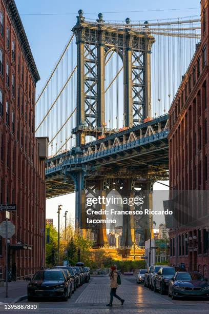 dumbo, brooklyn, new york city, usa. manhattan bridge and city buildings, woman crossing - manhattan bridge stock pictures, royalty-free photos & images