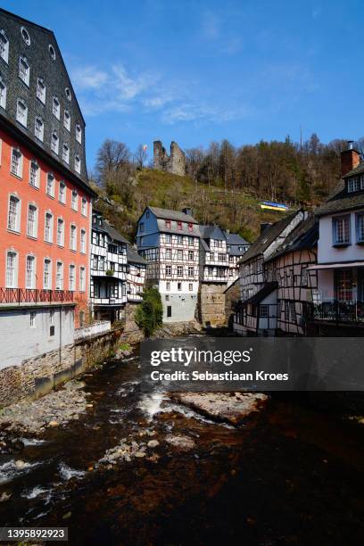 ruhr river flowing along the historic houses, tower, monschau, germany - the medieval city of monschau foto e immagini stock