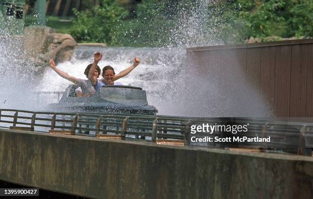 View of park-goers, their arms in the air, as they ride the 'Log Flume' at Six Flags Great Adventure, Jackson, New Jersey, July 1981.