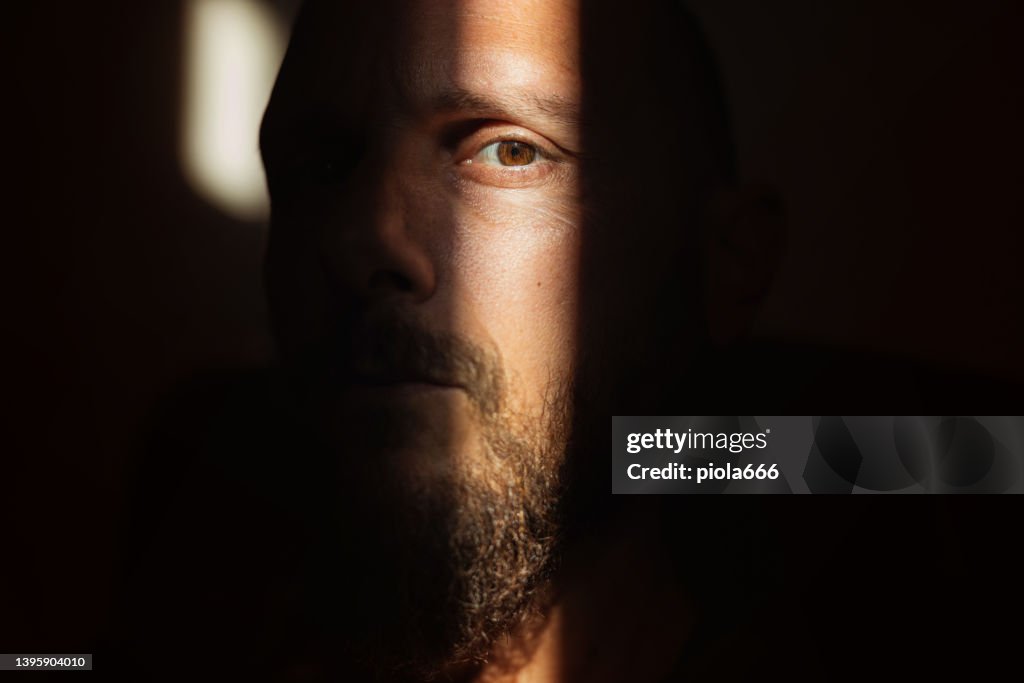 Dramatic light portrait: bearded man in the shadow