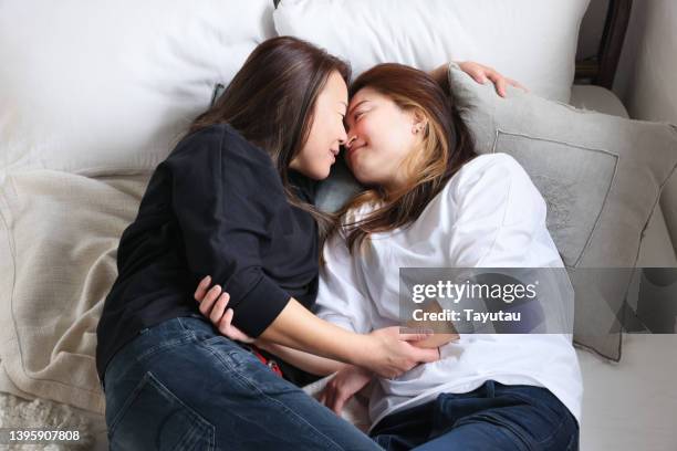 studio portrait of lgbtqia+ couple - asian lesbians kiss stock pictures, royalty-free photos & images
