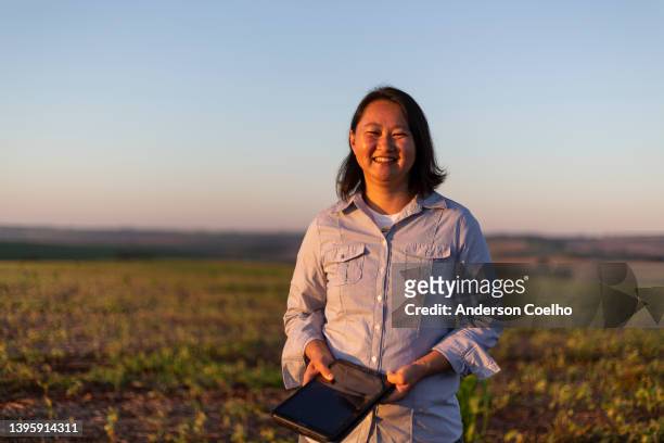 porträt einer japanerin in einer plantage bei sonnenuntergang - farmer female confident stock-fotos und bilder