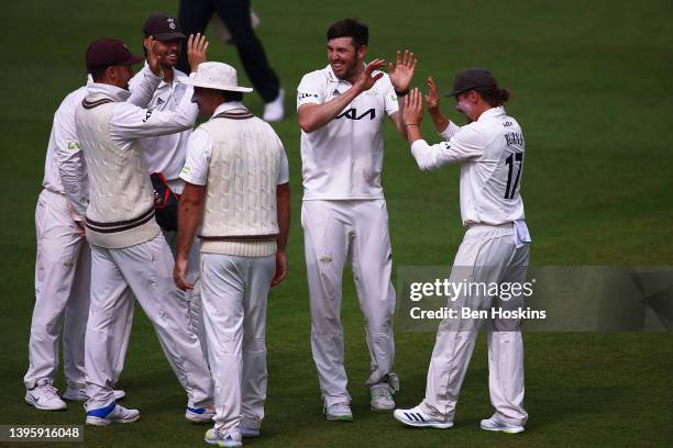 Jamie Overton of Surrey celebrates with team mates after taking the wicket of Saif Zaib of Northamptonshire during the LV= Insurance County...