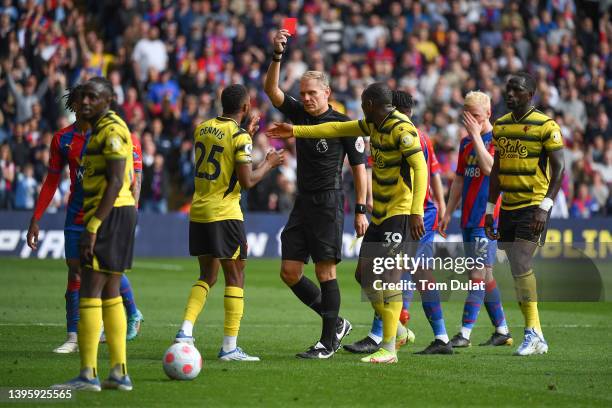 Hassane Kamara of Watford FC is shown a red card by referee Graham Scott after a foul on Michael Olise of Crystal Palace during the Premier League...