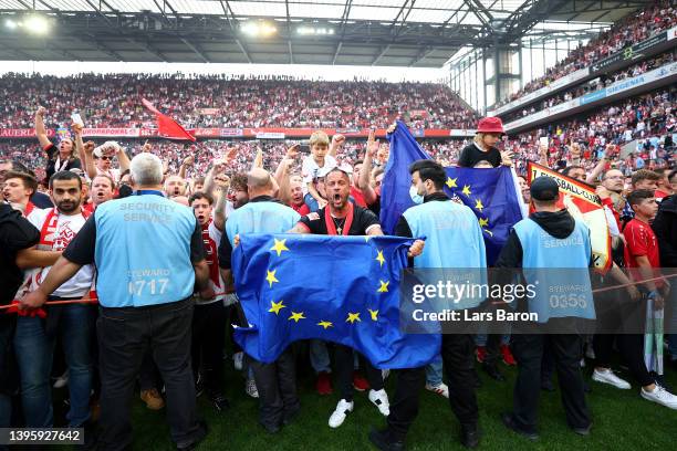 Koeln fans celebrate with EU flags after their sides qualification for European football during the Bundesliga match between 1. FC Köln and VfL...