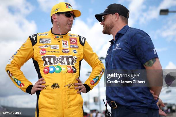 Kyle Busch, driver of the M&M's Toyota, and Trackhouse Racing team co-owner Justin Marks talk on the grid during qualifying for the NASCAR Cup Series...