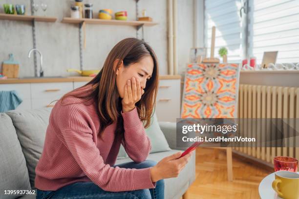 woman receiving shocking message - pessimism stock pictures, royalty-free photos & images