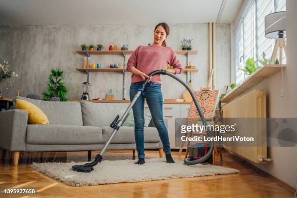 woman with backache vacuuming - vacuum cleaner woman stock pictures, royalty-free photos & images