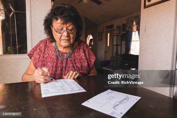 senior navajo woman voting by mail ballot - voting by mail stockfoto's en -beelden