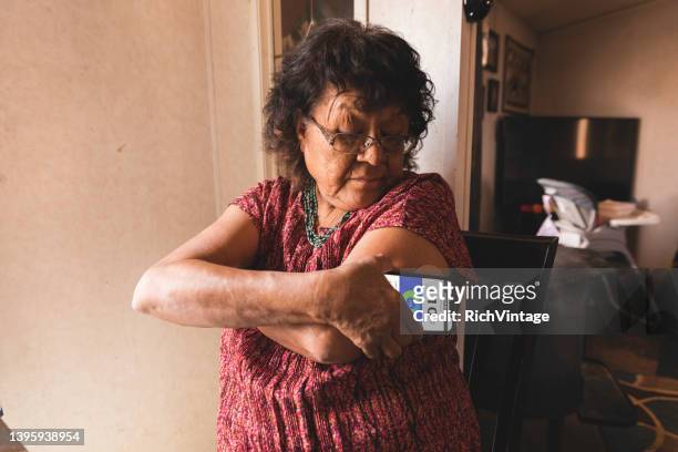 senior woman checks blood glucose - glucose stockfoto's en -beelden