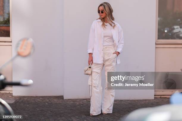 Isabelle Hartmann seen wearing a round sunglasses from Ray Ban, a white logo top from Off White, a white shirt blouse from Iro, a creme cargo pants...