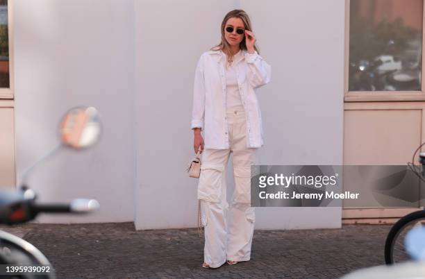 Isabelle Hartmann seen wearing a round sunglasses from Ray Ban, a white logo top from Off White, a white shirt blouse from Iro, a creme cargo pants...
