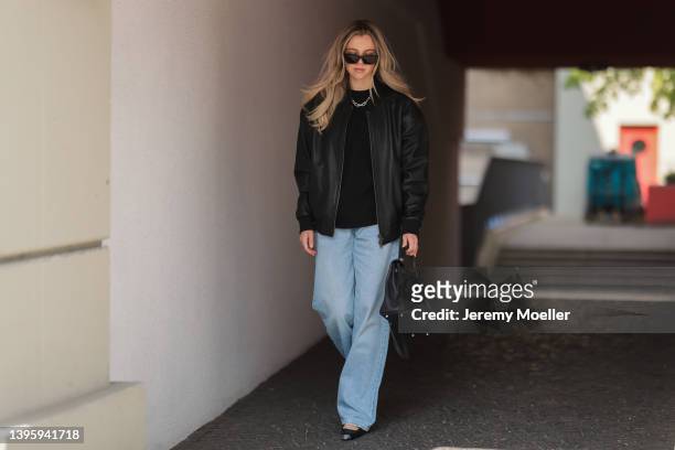 Isabelle Hartmann seen wearing a black sunglasses from Saint Laurent, a silver Tiffany & Co Hardwear necklace, a black shirt from The Frankie Shop, a...
