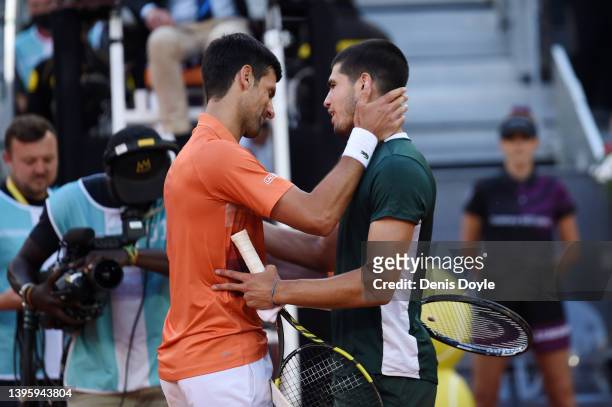 Novak Djokovic of Serbia and Carlos Alcaraz of Spain interact by the net after their Men's Singles Semi-finals match during day ten of Mutua Madrid...