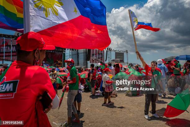 Supporters of Ferdinand "Bongbong" Marcos Jr. And running mate Sara Duterte wave Philippine flags during their last campaign rally before the...