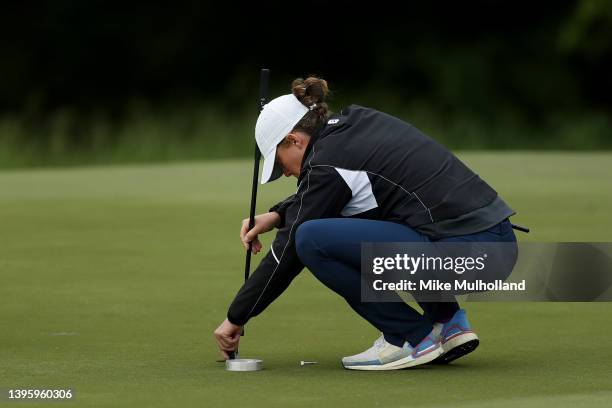 Rules official fixes the cup after Tom Whitney holed out his approach shot on the eighth hole for an eagle during the third round of the Simmons Bank...