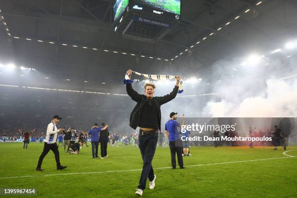 Fans celebrate on the pitch following the Second Bundesliga match between FC Schalke 04 and FC St. Pauli at Veltins Arena on May 07, 2022 in...