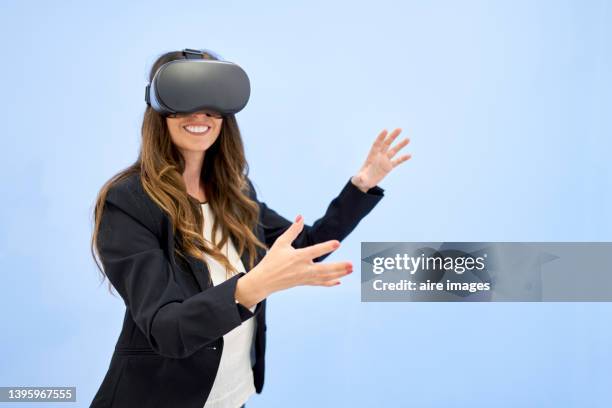 business woman smiles gesturing while wearing virtual reality simulator eyeglasses - virtual reality point of view stock pictures, royalty-free photos & images