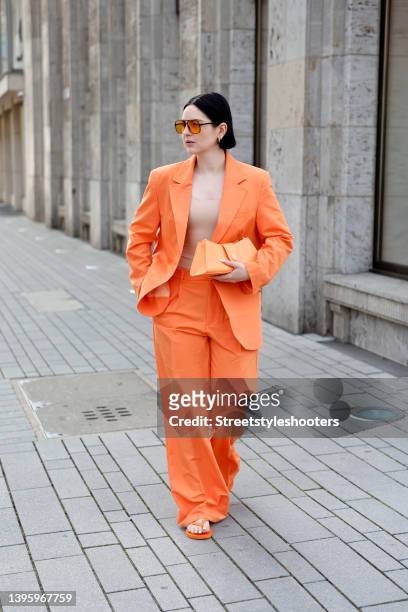 Influencer Maria Barteczko wearing a pastel orange oversized suit by Bershka, orange flip flops by Havaianas, a light orange clutch by Topshop,...