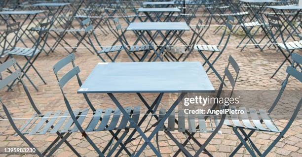 a bar terrace with chairs and tables creating a geometric composition. - turín stock-fotos und bilder