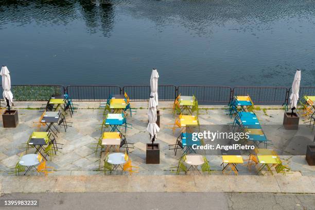 colored chairs and tables to take a drink close the river. - turín stock pictures, royalty-free photos & images