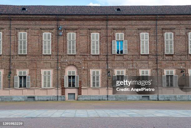 extensive stone and brick facade of a historic building - turín stock-fotos und bilder