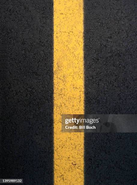 new yellow line on new asphalt road - yellow line stockfoto's en -beelden
